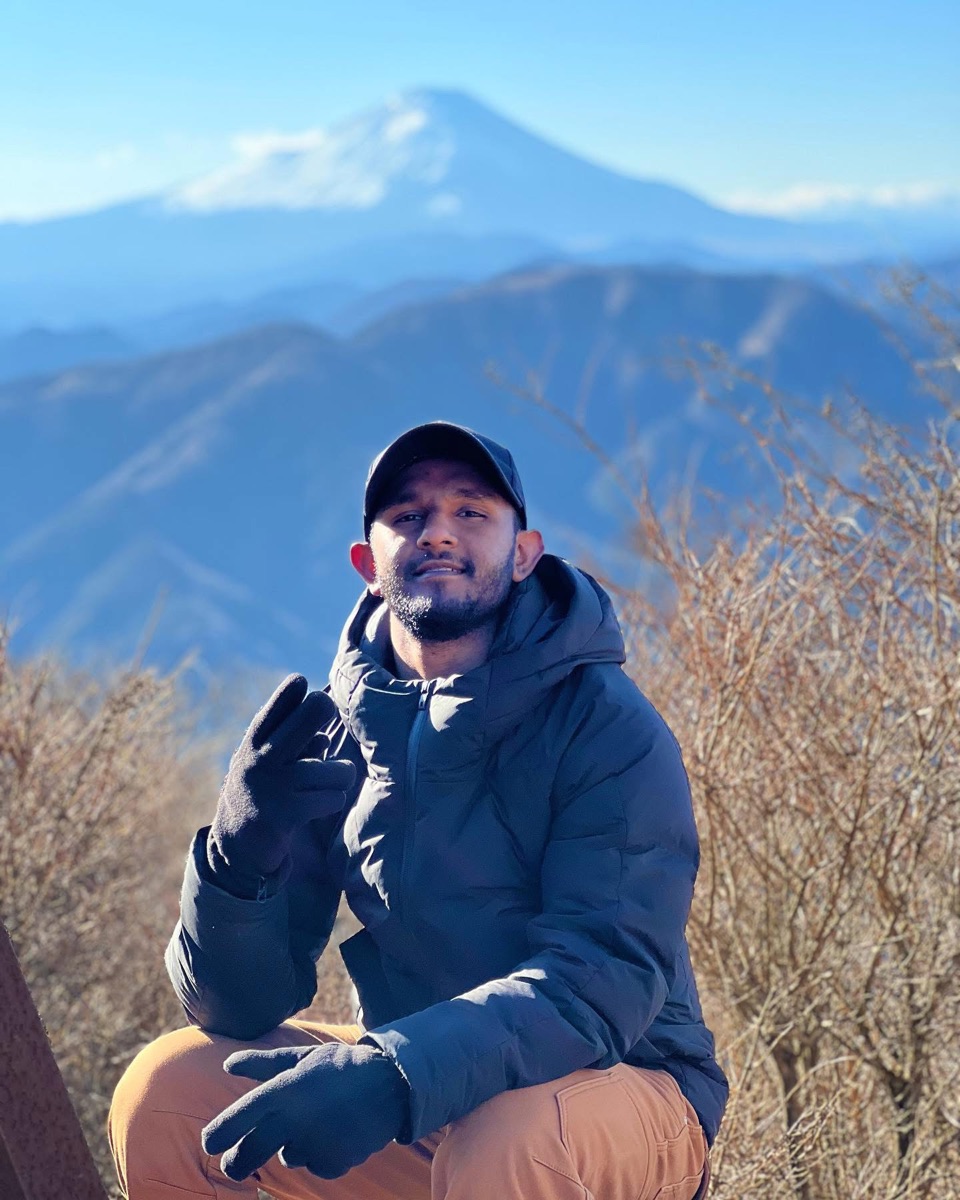 Inthikaf Ahamed, founder of Celvyr, in the mountains of Japan with Mount Fuji behind him